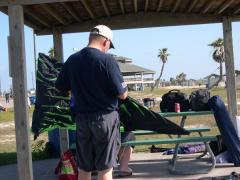 T C  assembles one of mis "Parrot Head" kites