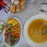 A traditional Spanish meal, complete with slow cooked beef and vegetables, along with a rice soup.